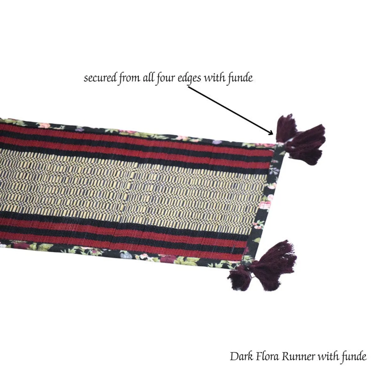 Close view of floral edging and dark tassel detail on the table runner