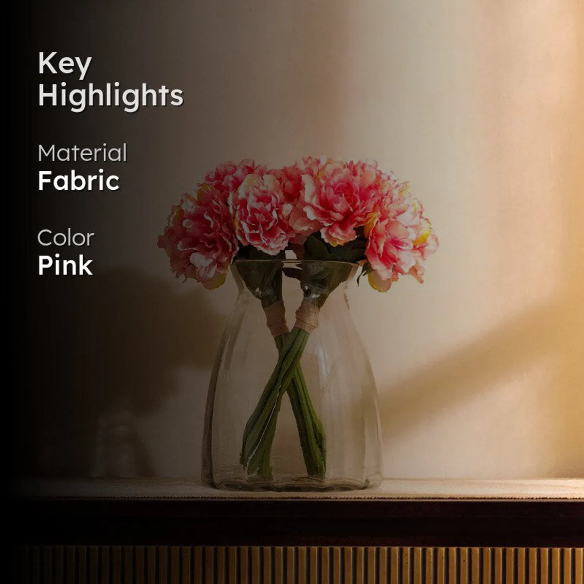 Pink artificial peony bouquet displayed in a vase against a warm background