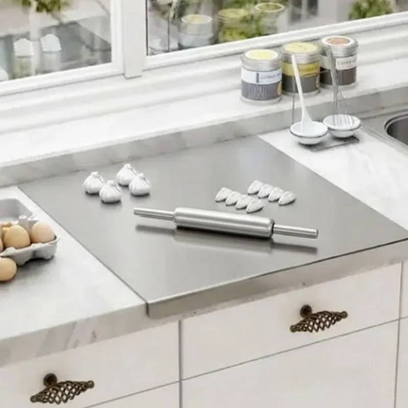 Steel rolling pin and board set displayed near a kitchen window