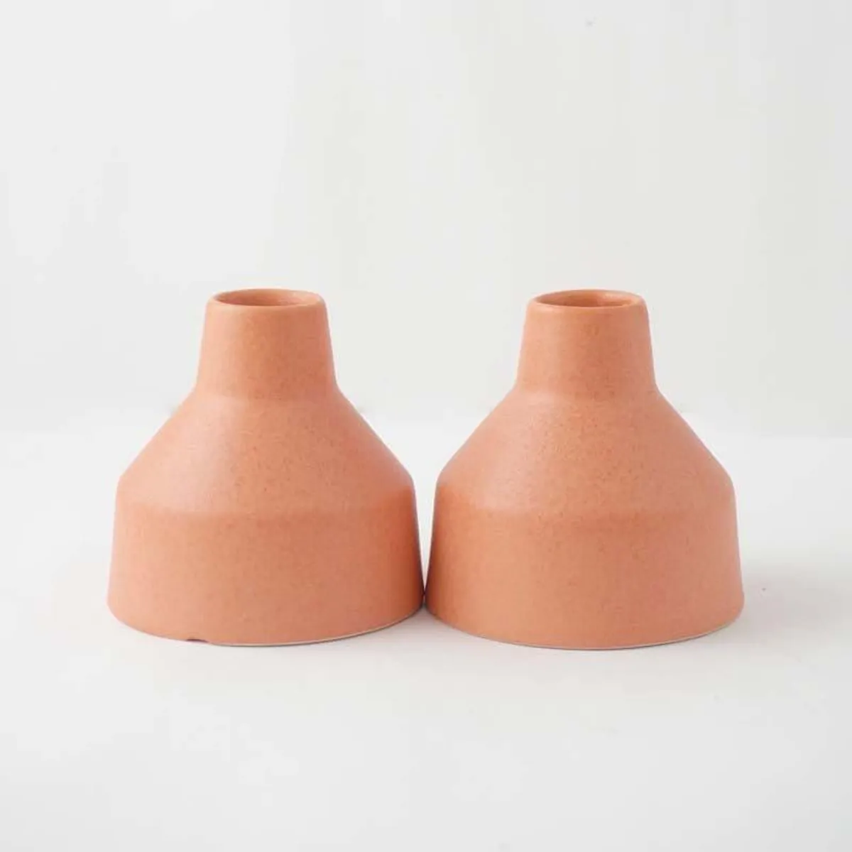 Set of two blush pink ceramic vases against a plain white background