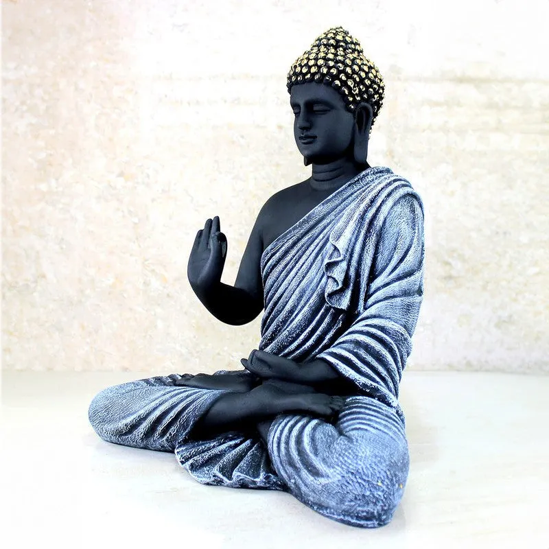Angled right view of seated Buddha idol with silver drapery