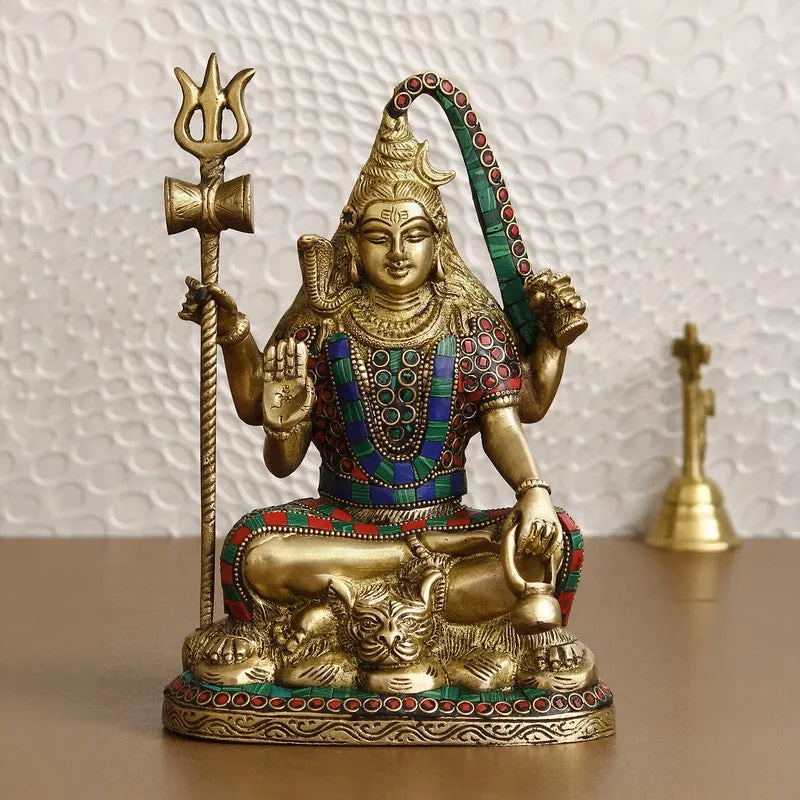 Front view of a gold-toned deity idol with blue and red detailing