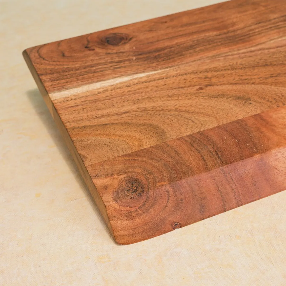 Close-up of the chopping board showing its warm wood grain and smooth surface