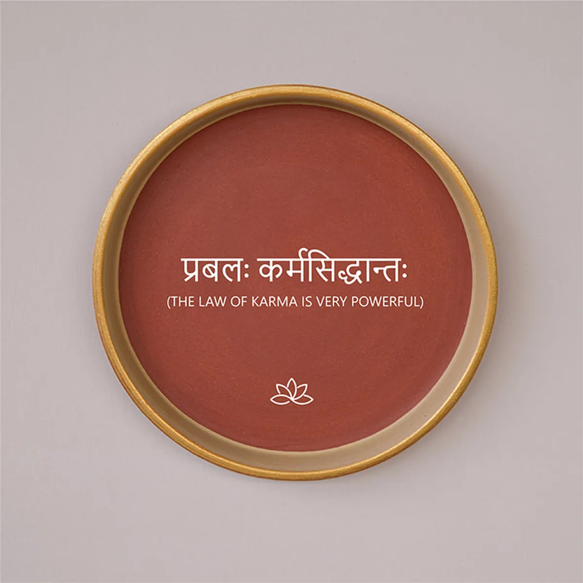 Close view of round terracotta wall plate with white lettering