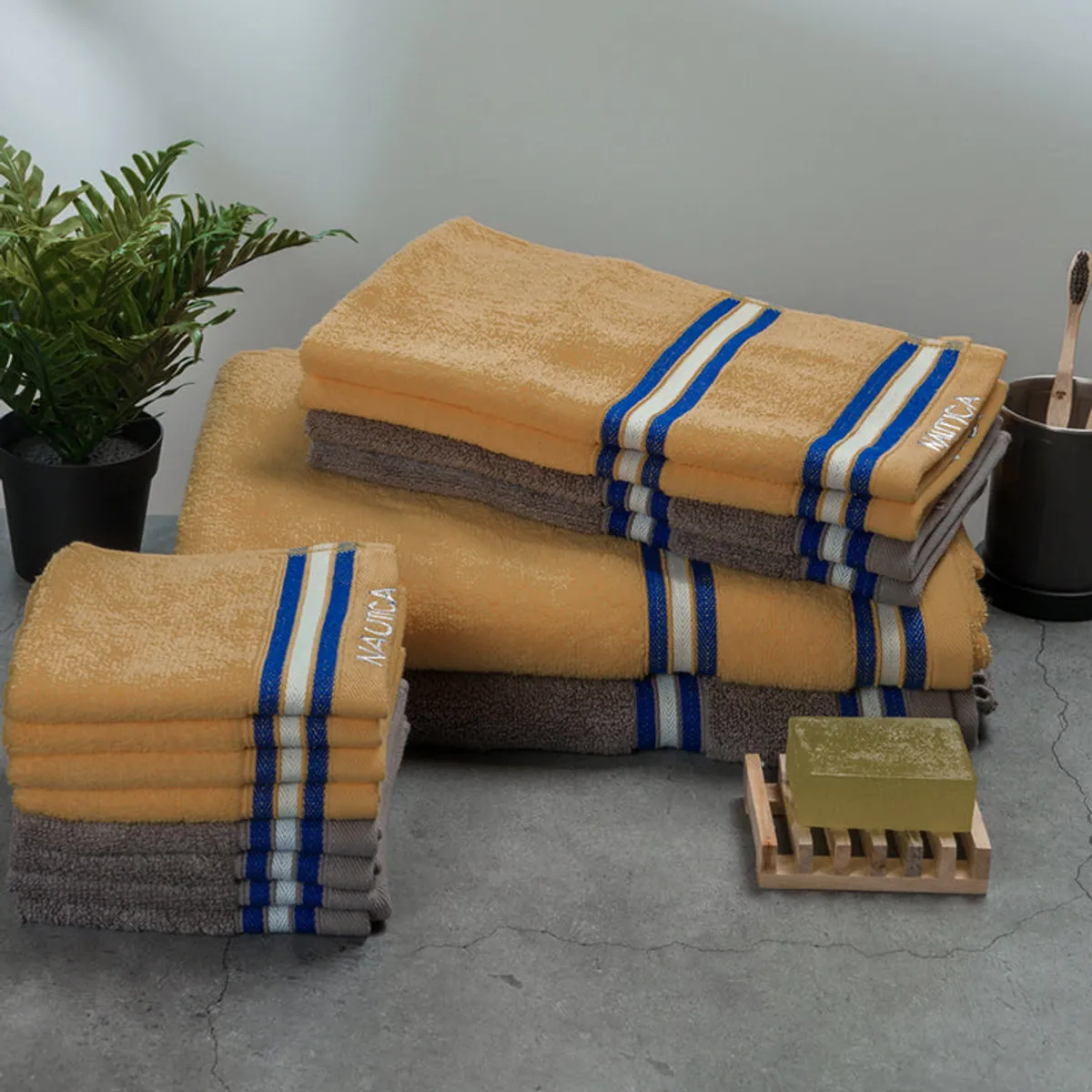 Yellow and grey striped towel set styled with soap and a plant