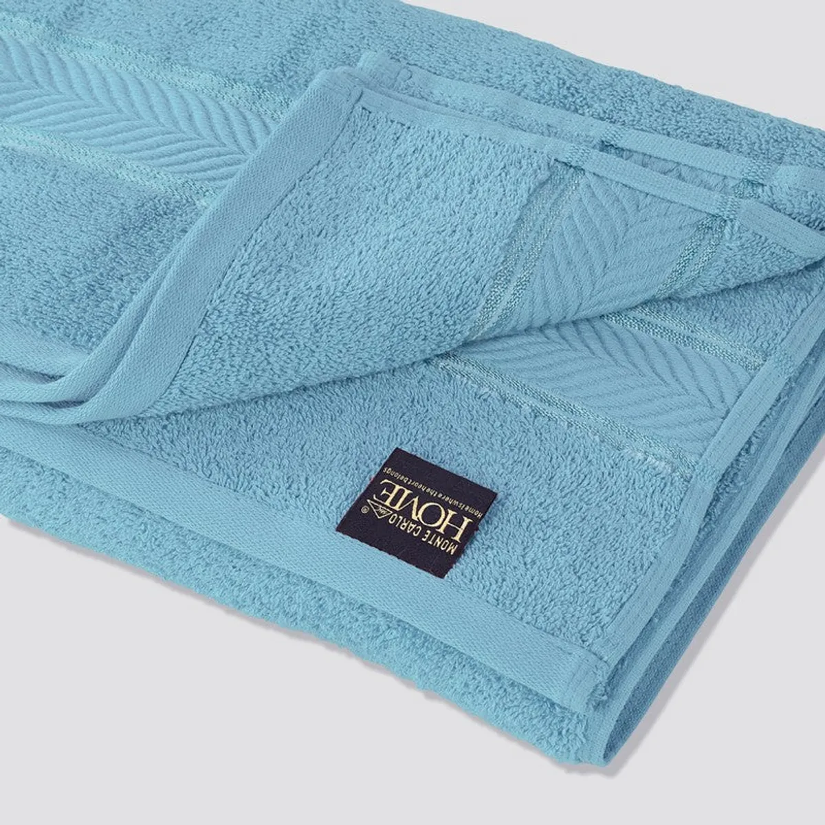 Close view of the dust blue towel's plush texture and patterned border