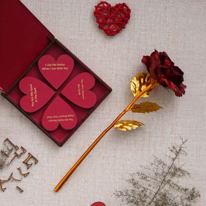 Open red gift box with heart-shaped notes and metallic rose