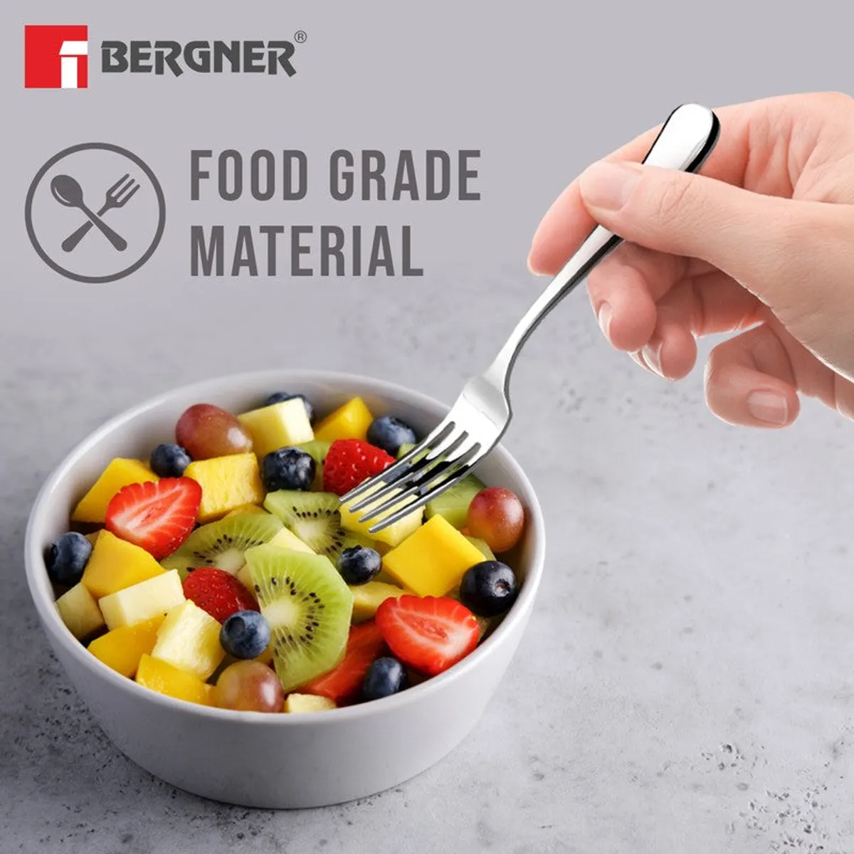 Silver fork held over a bowl of fruit, showing its food-grade design.