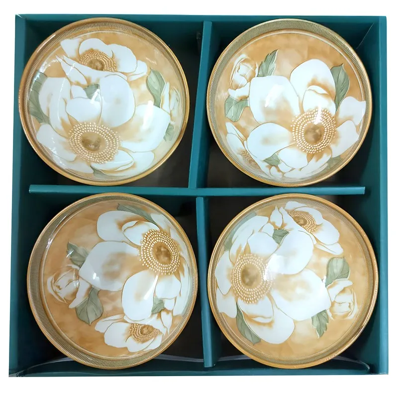 Four floral ceramic bowls arranged in a divided teal presentation box