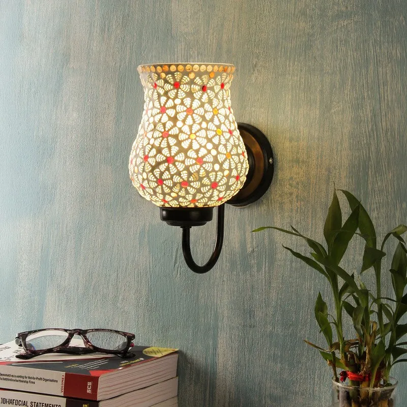 Lit white mosaic glass wall lamp mounted on a textured blue wall