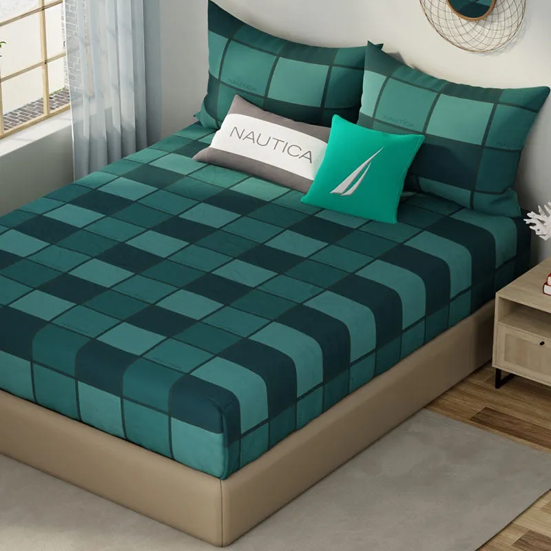 Green geometric checked bedsheet shown on a made bed from an angle