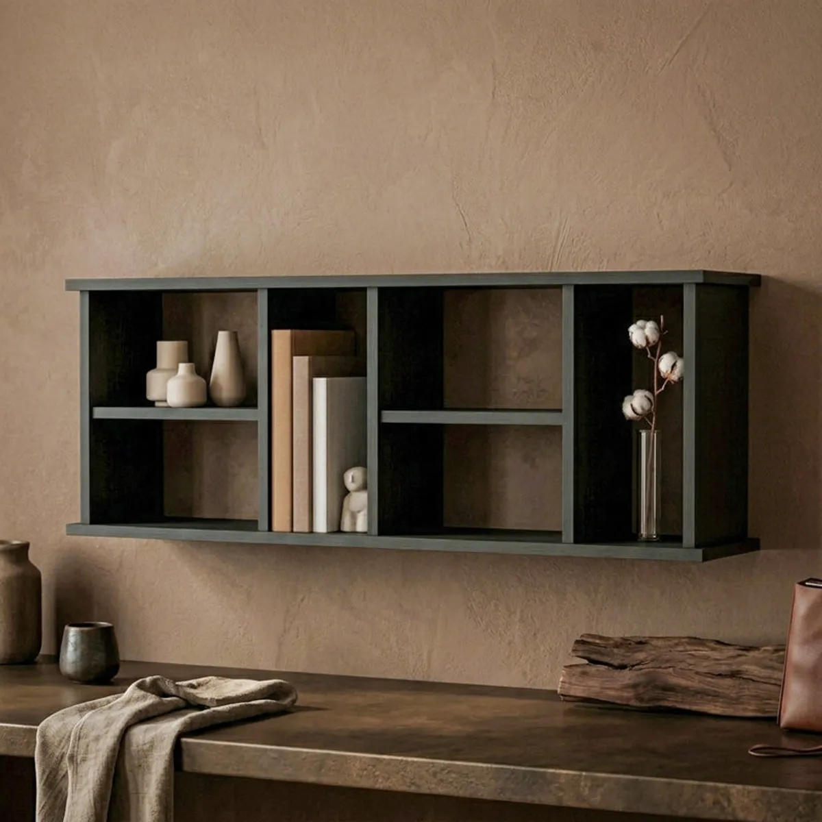 Black wall shelf styled with books and décor above a console in a warm living space.