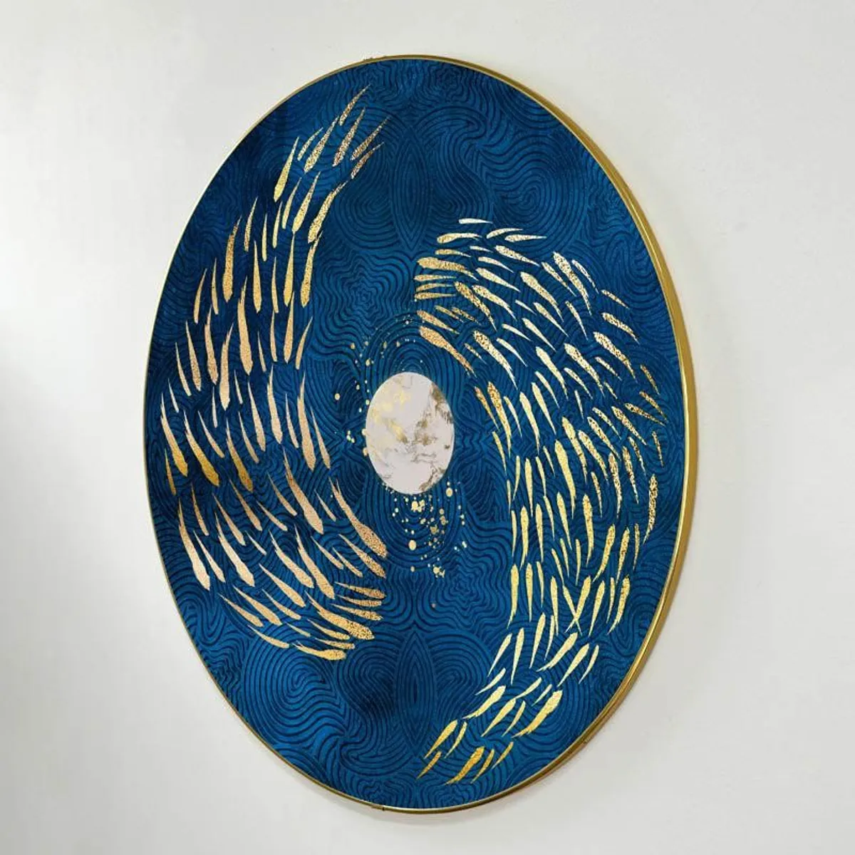 Front view of oval-round blue wall art with gold abstract swirls on a plain wall
