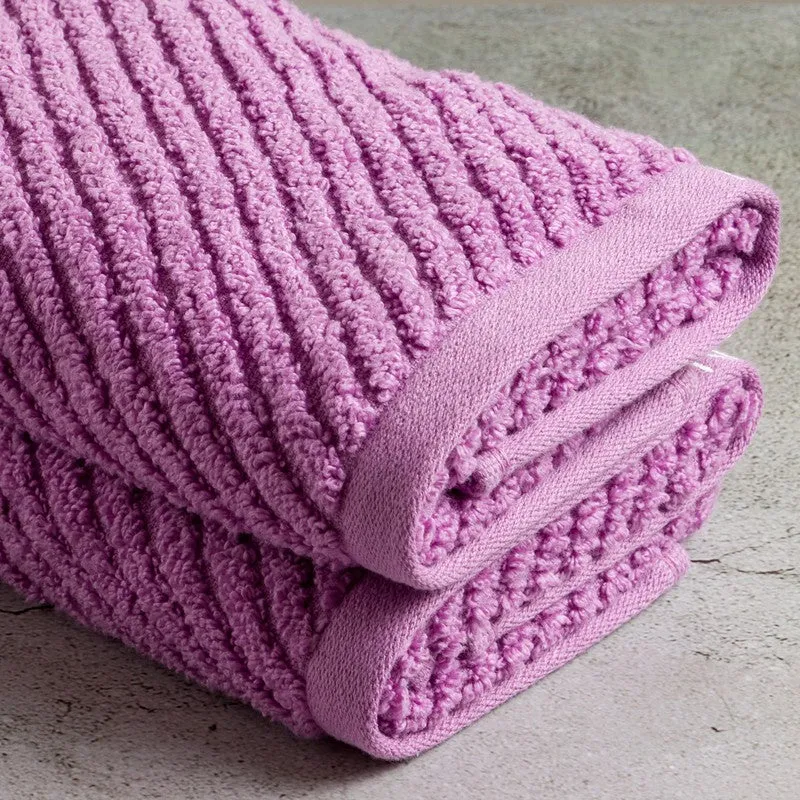 Close-up of folded lilac hand towels with plush ribbed texture