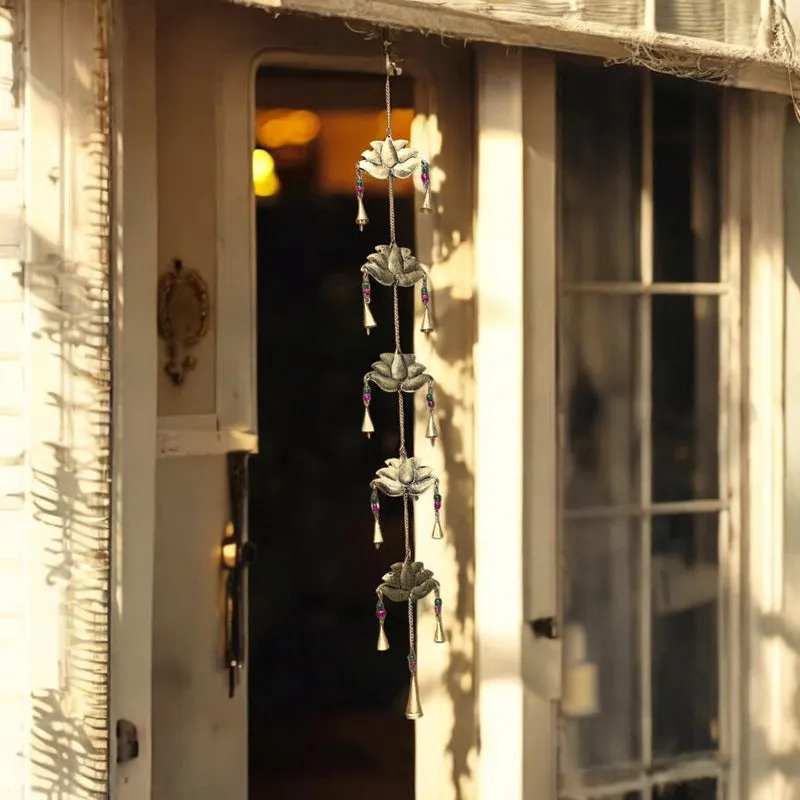 Gold lotus latkan hanging near a sunlit doorway