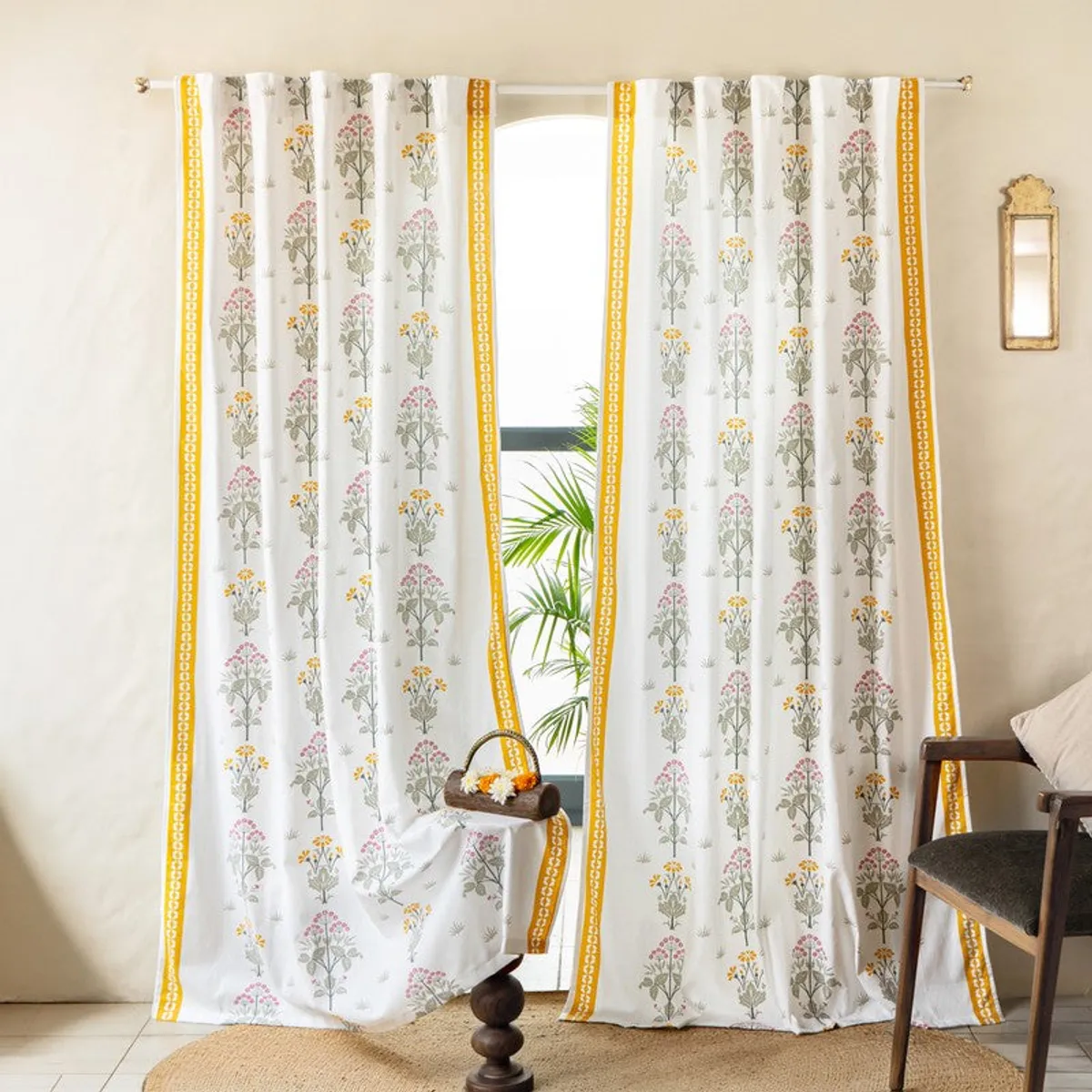 White cotton curtains with yellow floral trellis print framing a bright window