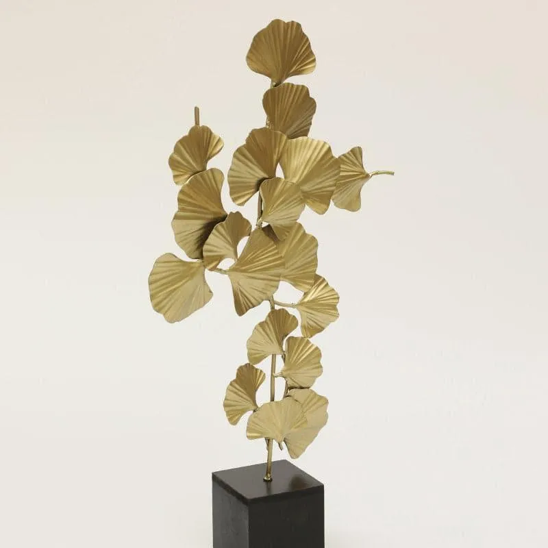 Full view of a gold leaf-inspired showpiece on a black rectangular base
