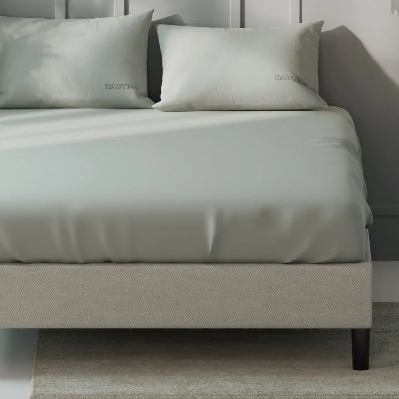 Close view of a smooth silver grey bedsheet draped over a bed