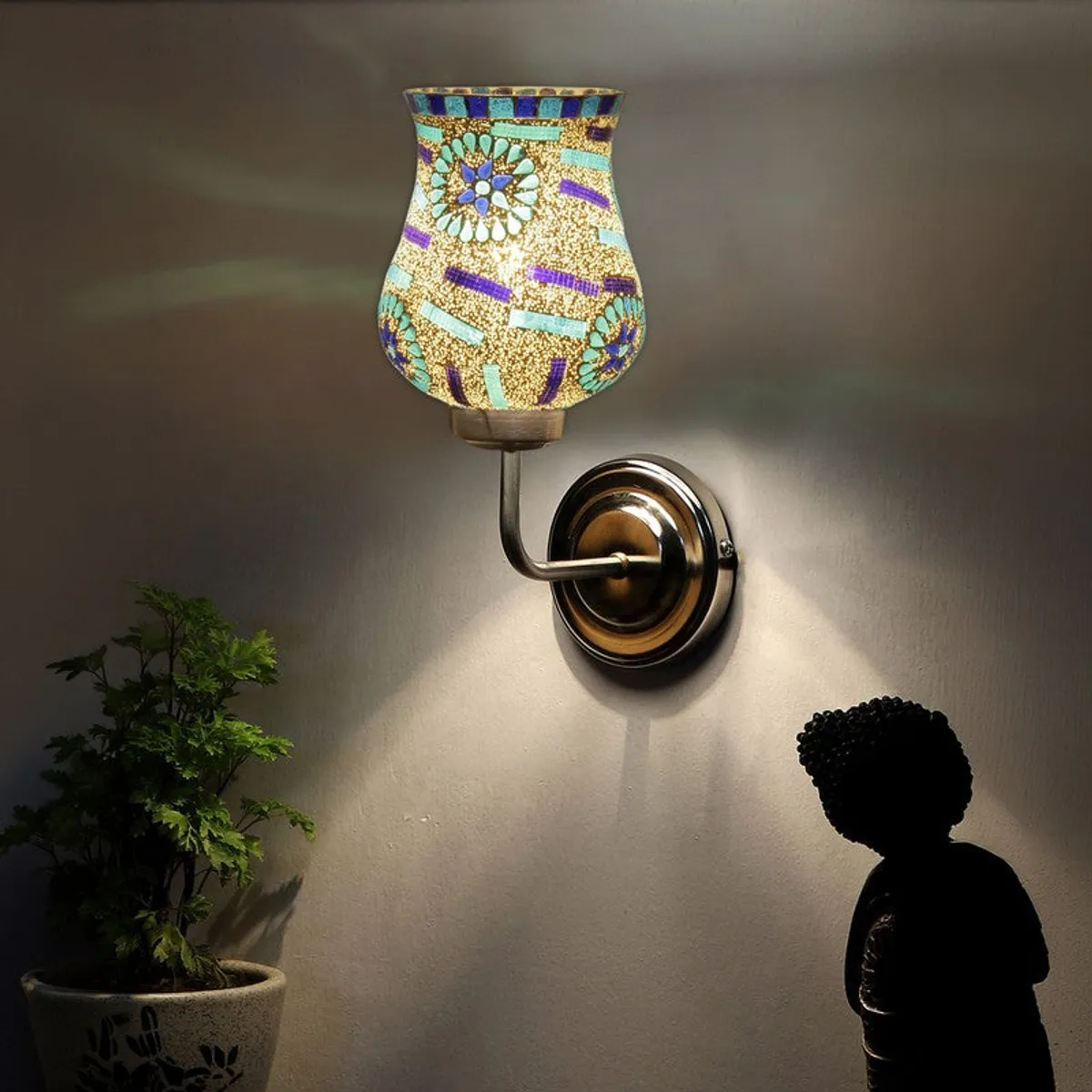 Wall-mounted lit mosaic glass lamp casting soft patterned light