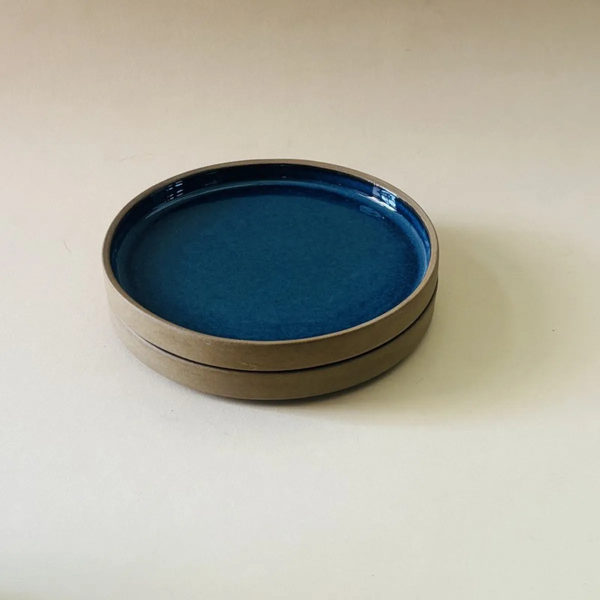 Two blue ceramic quarter plates stacked to show their rounded shape