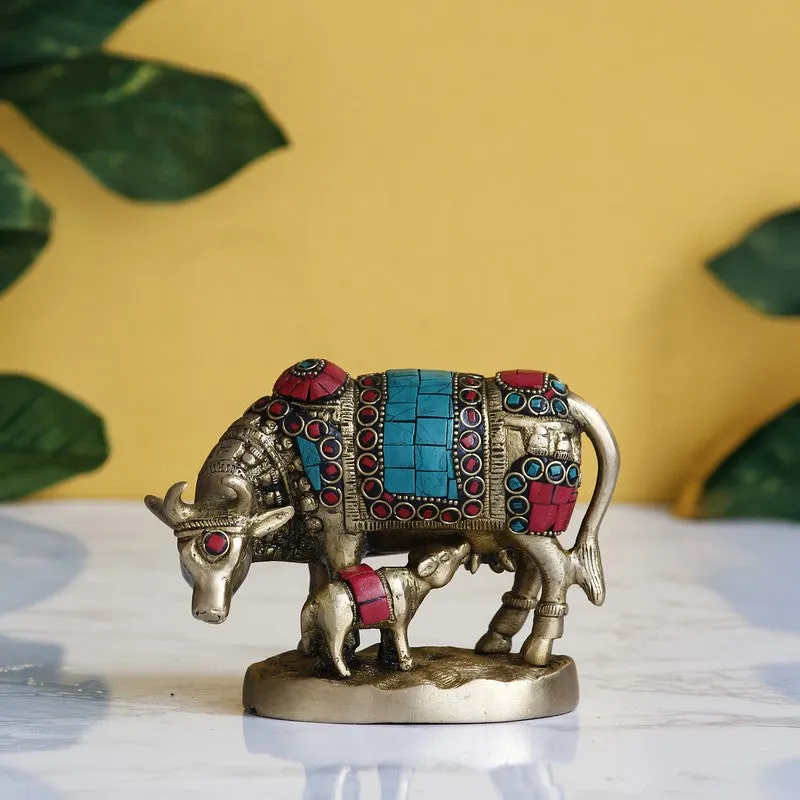 Multicolour Gau Mata brass idol with calf on a tabletop