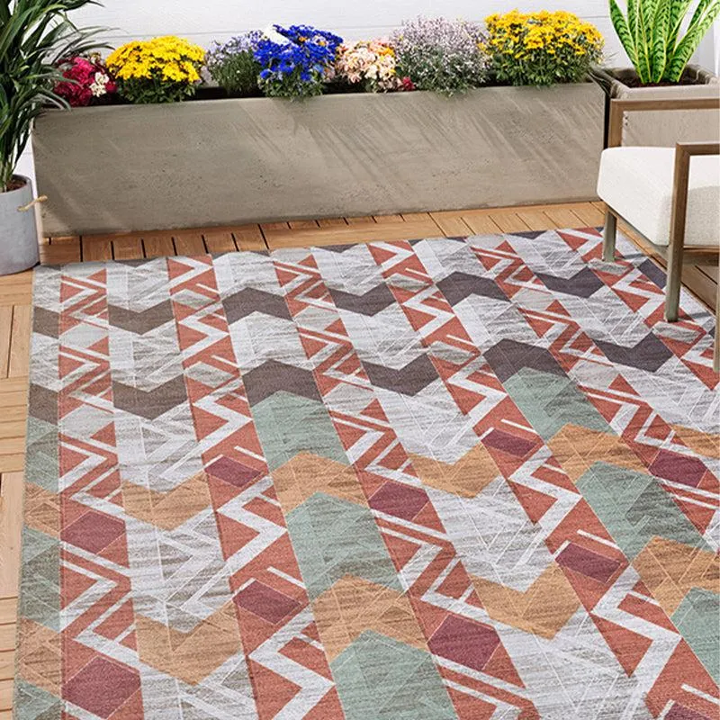 Geometric maroon and green rectangular carpet styled on a patio floor