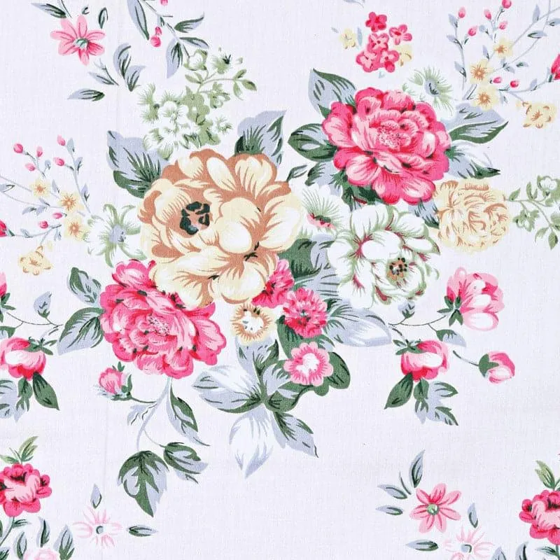 Close-up of the floral print in pink, cream and green on white fabric