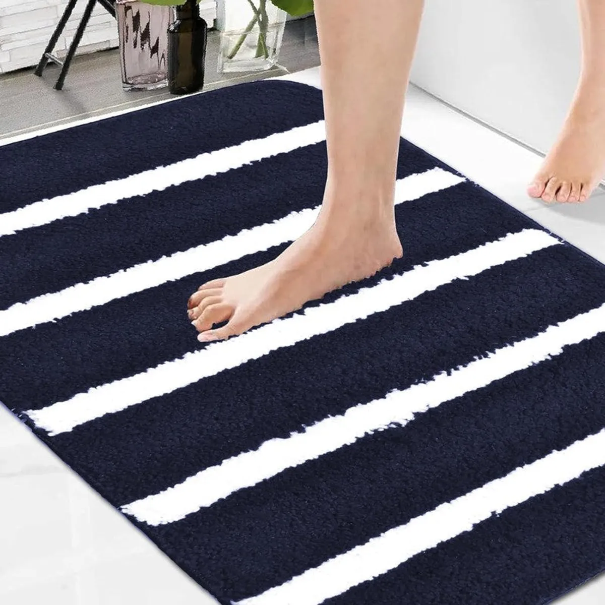 Close view of a blue and white striped bath mat with a soft textured surface