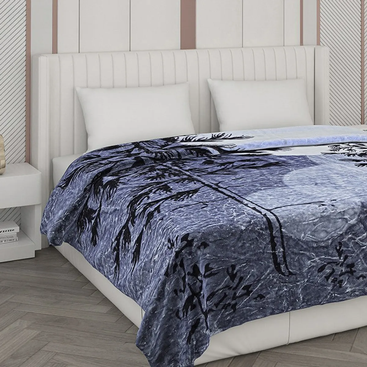 Close view of a blue botanical blanket across a bed