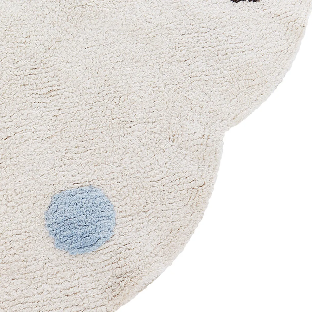 Close-up of the rug's scalloped edge and blue tufted dot