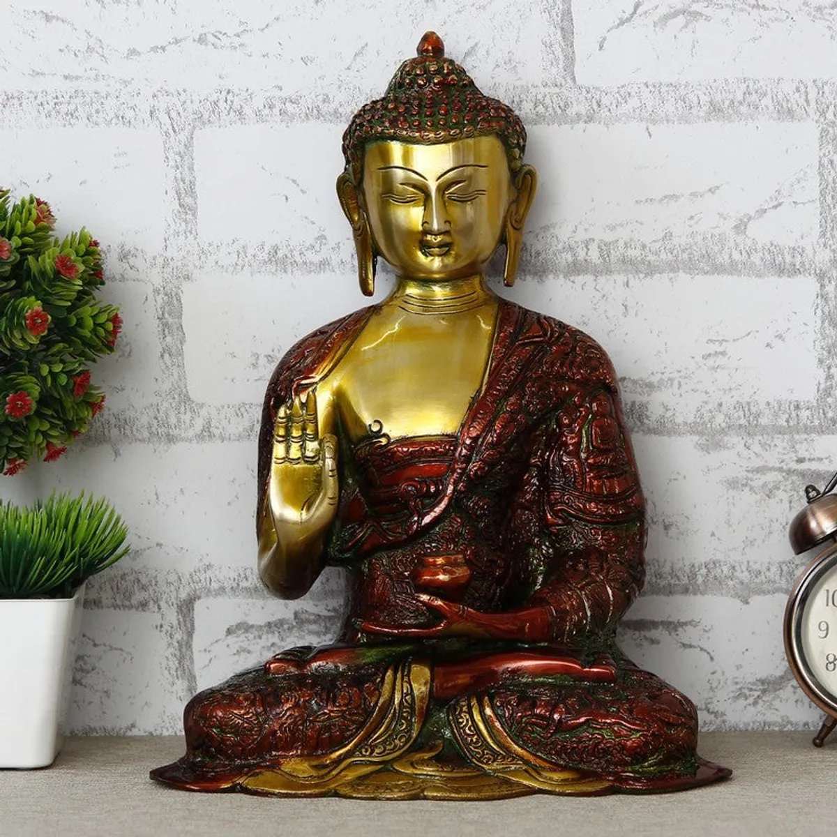 Front view of ornate Buddha idol in gold and deep red finish