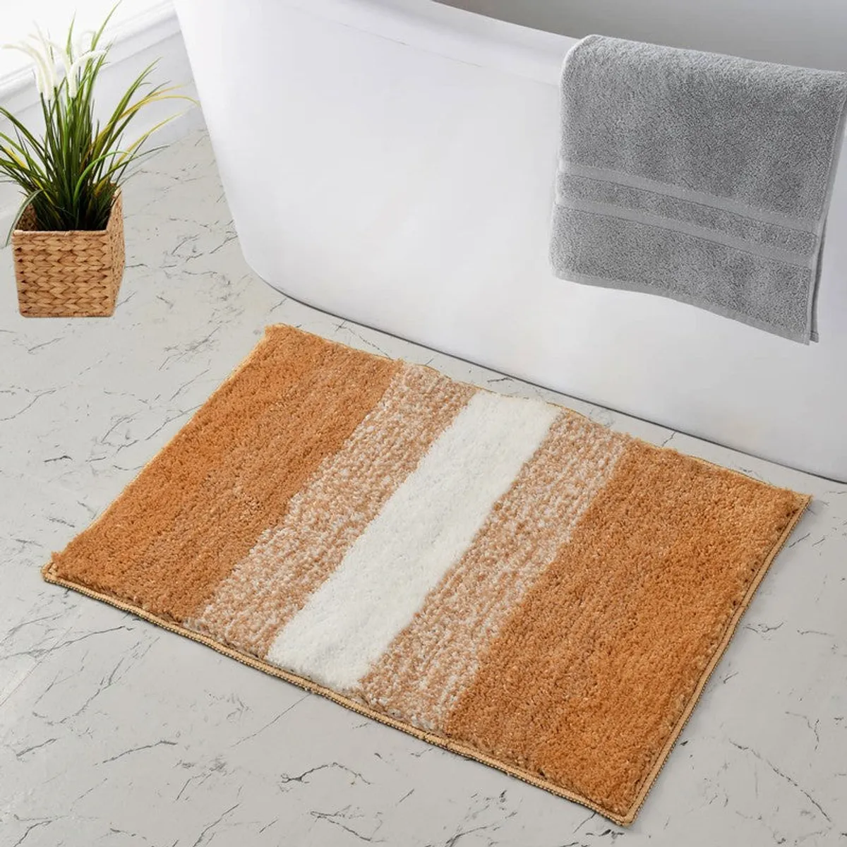 Rust and white striped bath mat placed beside a white bathtub