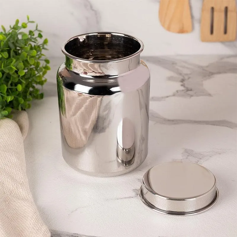 Open silver storage container with its lid placed beside it on a kitchen counter