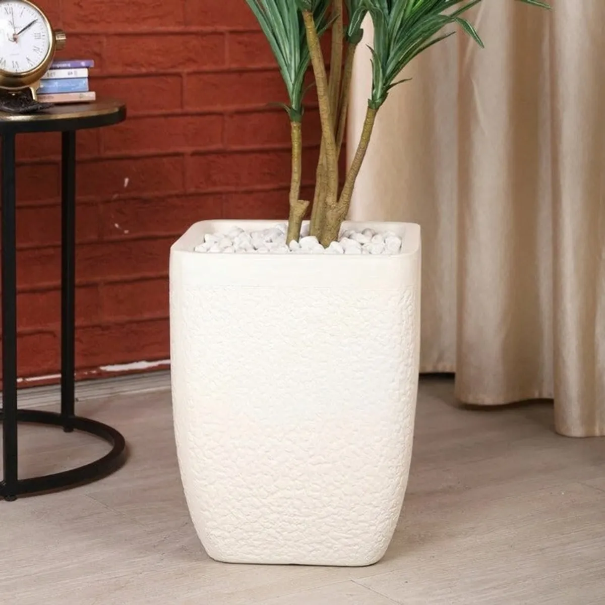 Close view of a white textured planter holding a leafy plant