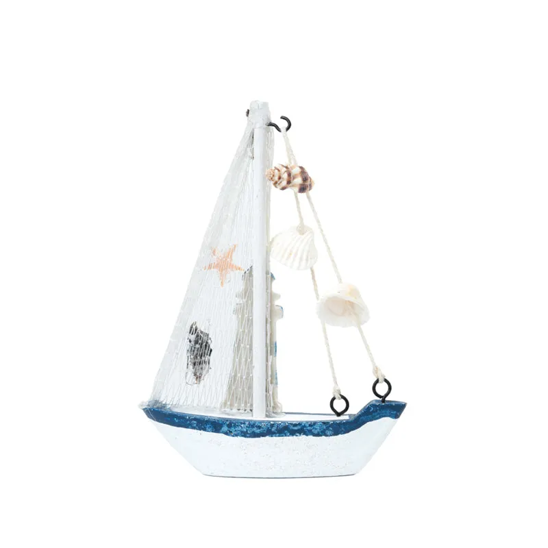 Side view of a white and blue sailboat showpiece with net sail and shell accents