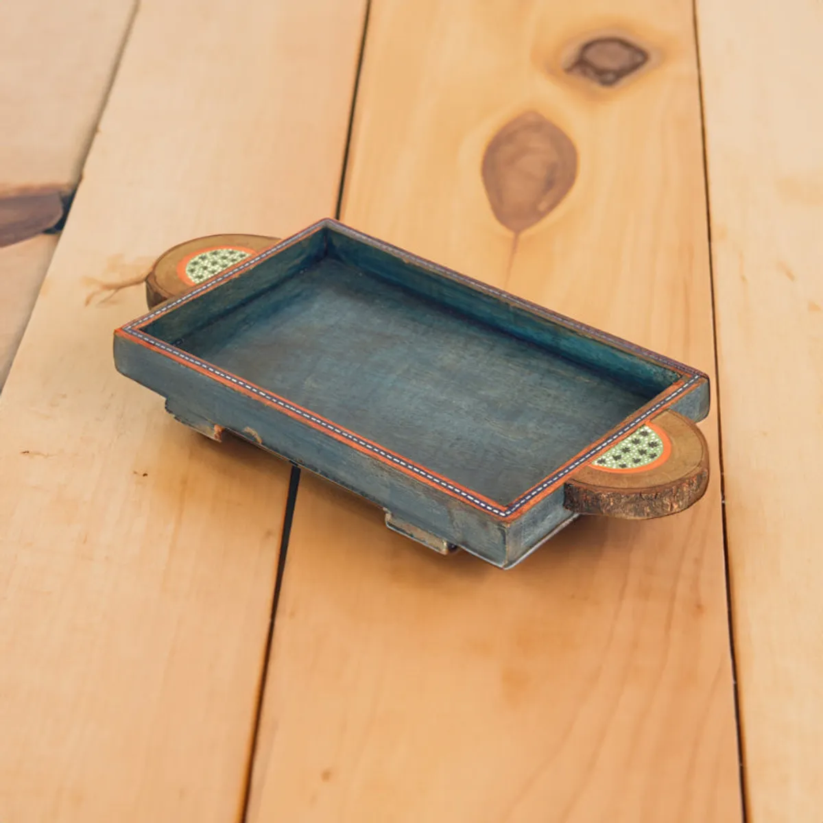 Distressed blue decorative tray displayed on a wooden tabletop