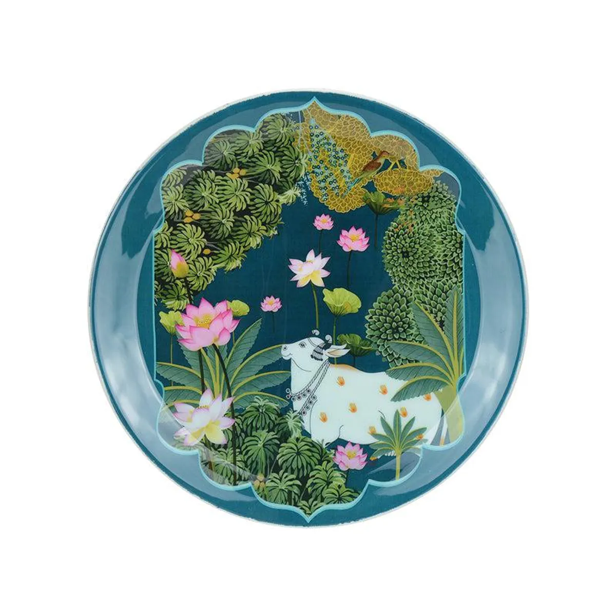 Blue round wall plate with a white cow surrounded by lotus flowers and foliage