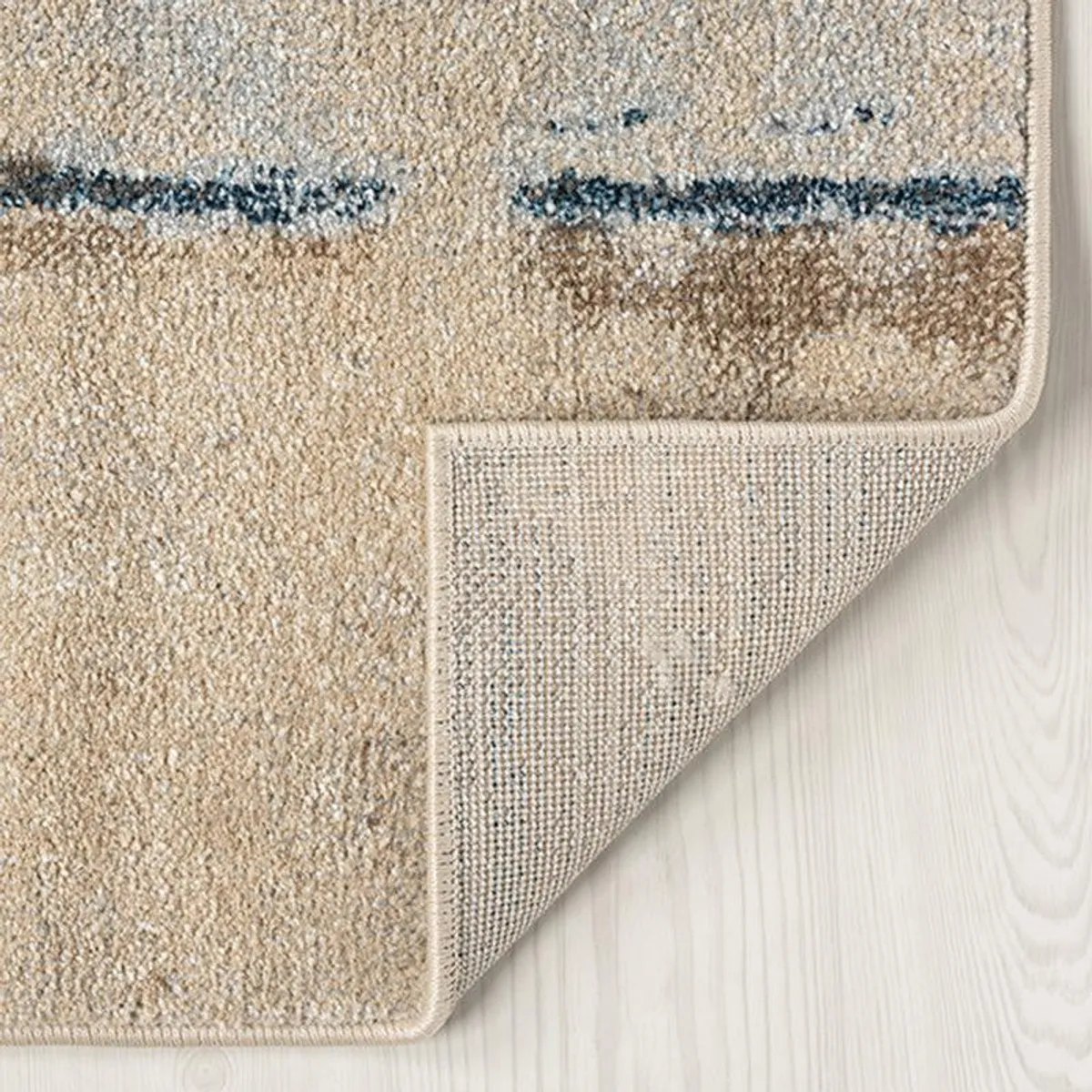 Close-up of the carpet's textured pile, bound edge and underside