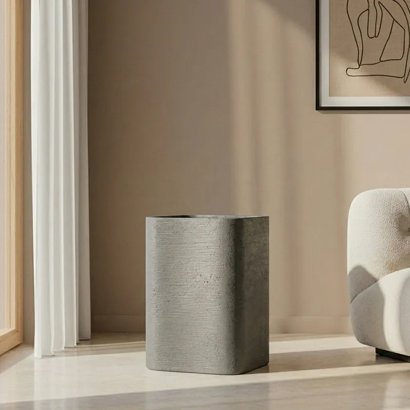 Grey rectangular planter placed beside a light-coloured armchair