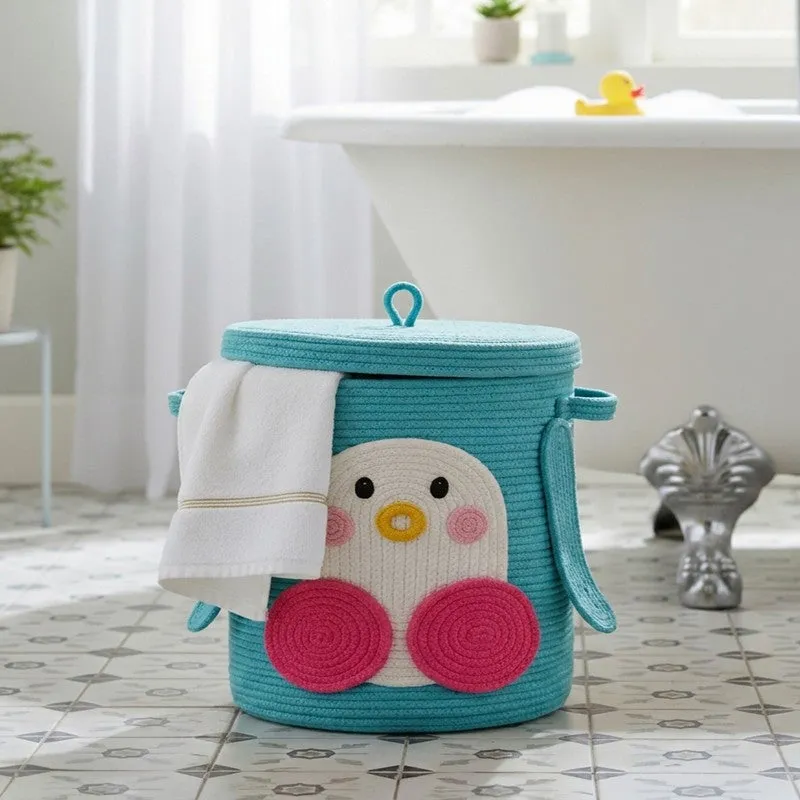 Blue cylindrical storage basket with penguin motif and lid in a bathroom setting