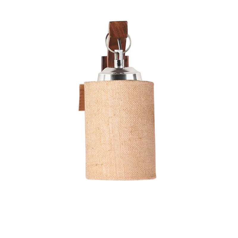 Front view of beige cylindrical fabric wall lamp with wooden mount