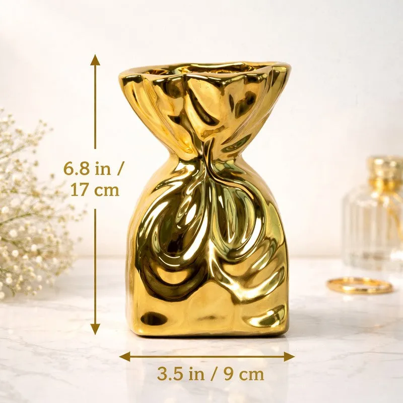 Gold sculptural vase shown alone on a tabletop in a styled interior setting