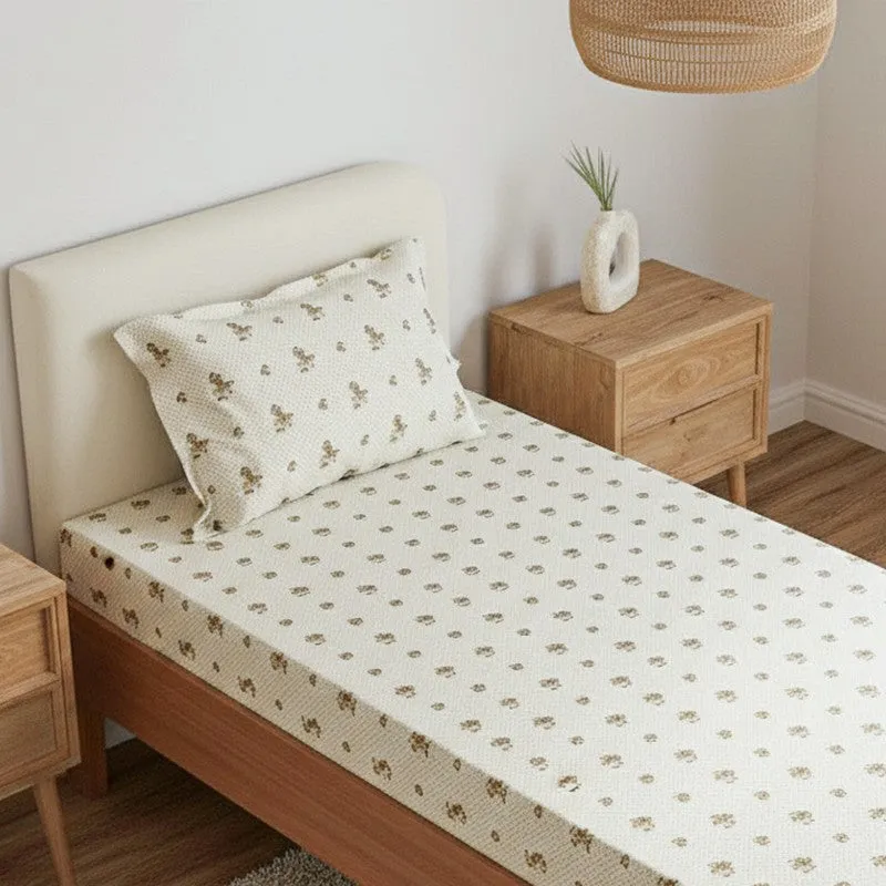 Close view of off-white floral bedsheet and matching pillow cover on a single bed