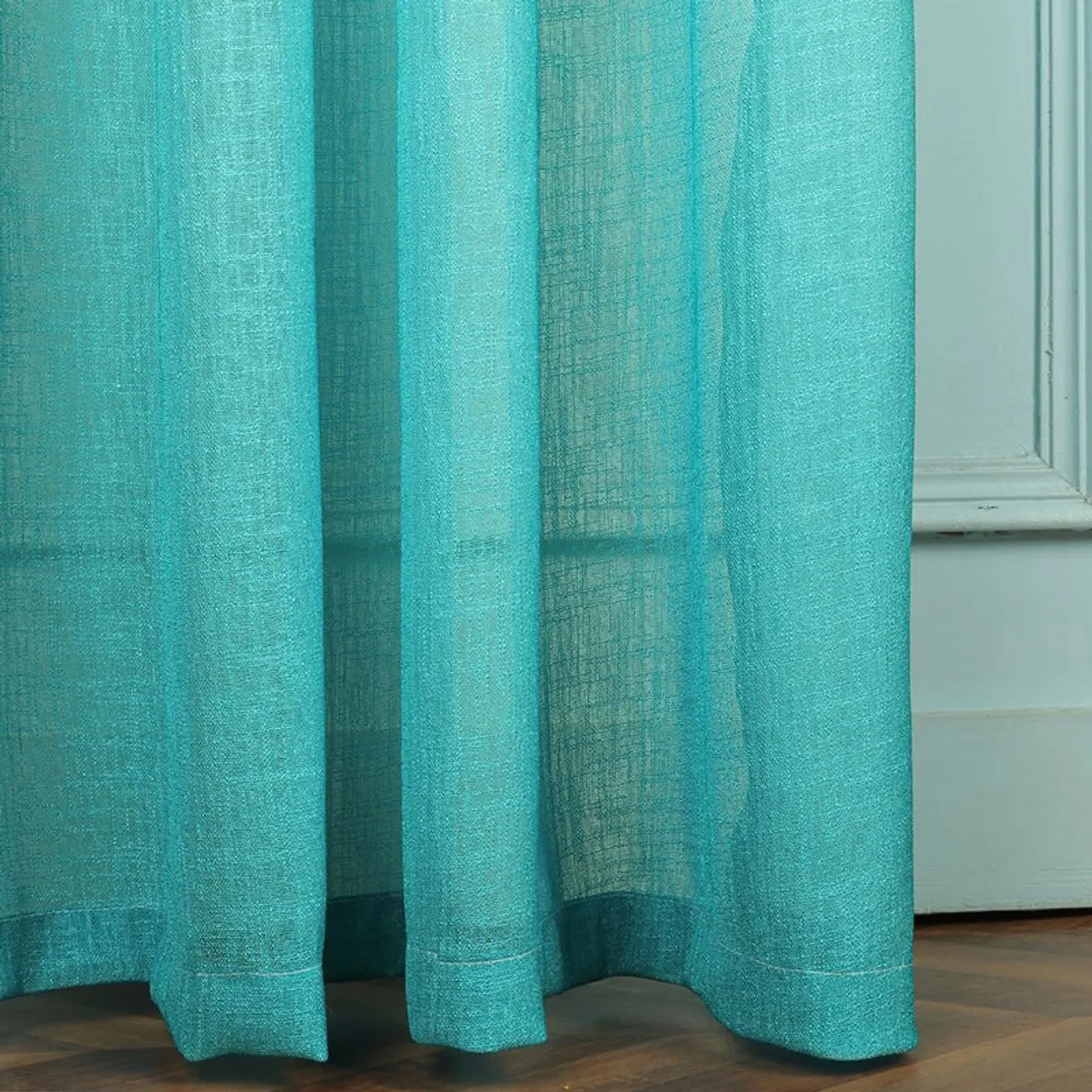 Close-up of turquoise curtain folds and textured surface