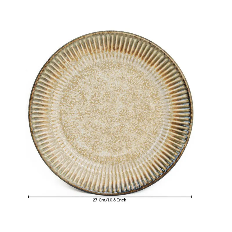 Close-up of a round beige ceramic dinner plate with textured rim
