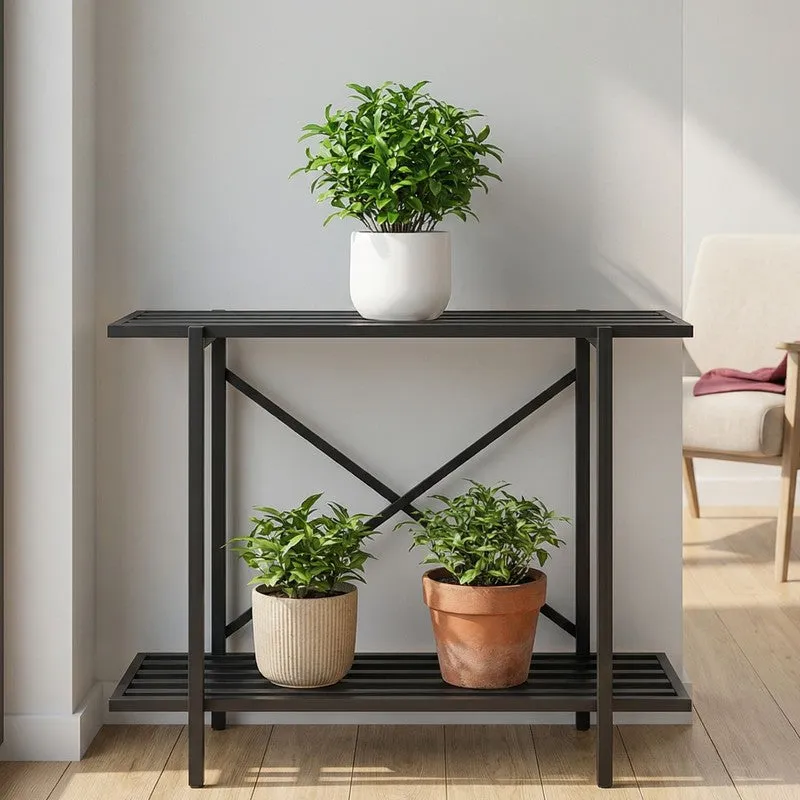 Black metal planter stand displaying three plants against a living room wall