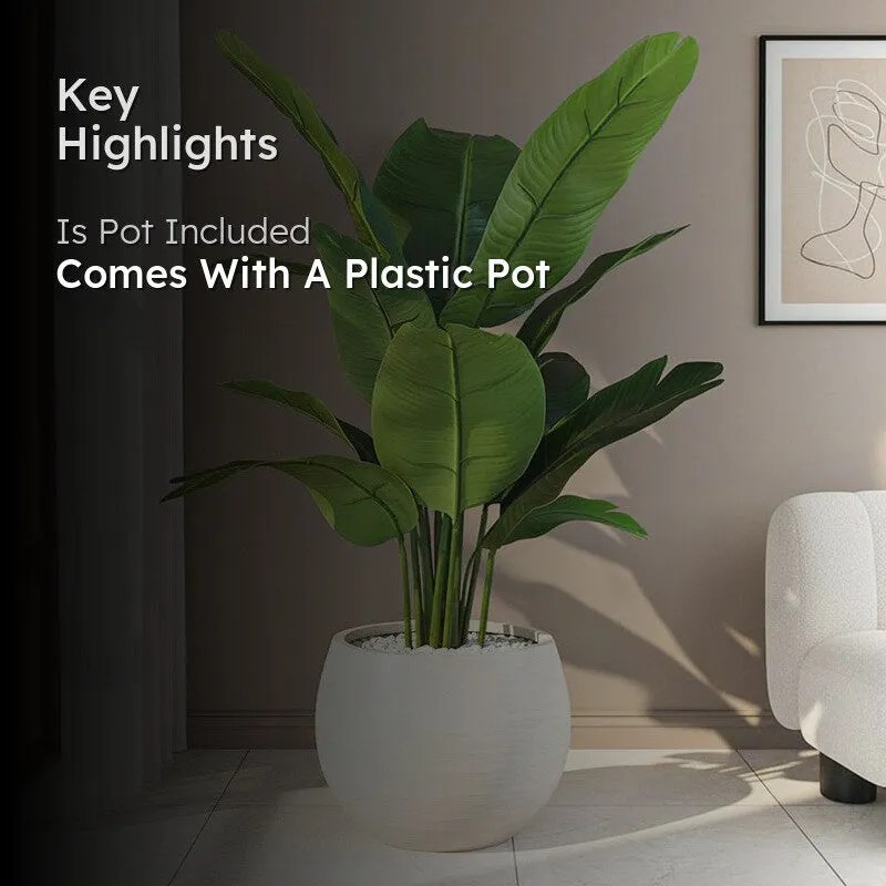 Artificial banana plant in a black plastic pot shown in a room setting