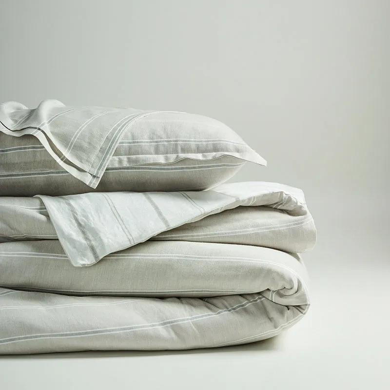 Folded beige striped bedding with a matching pillow cover.