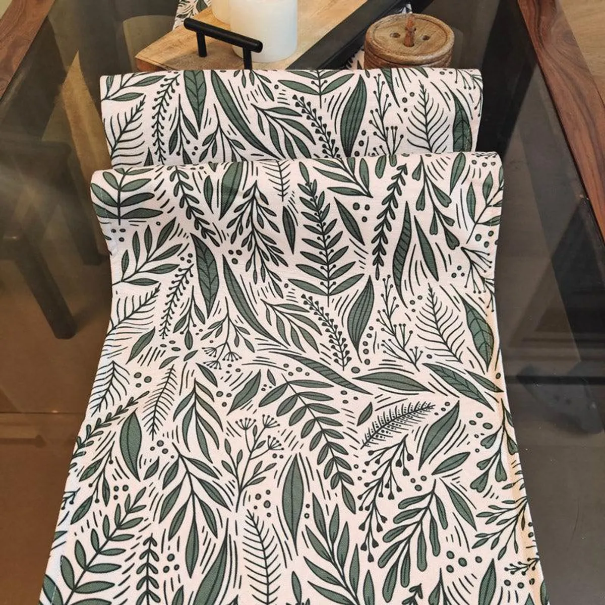 Green botanical table runner spread across a dining table