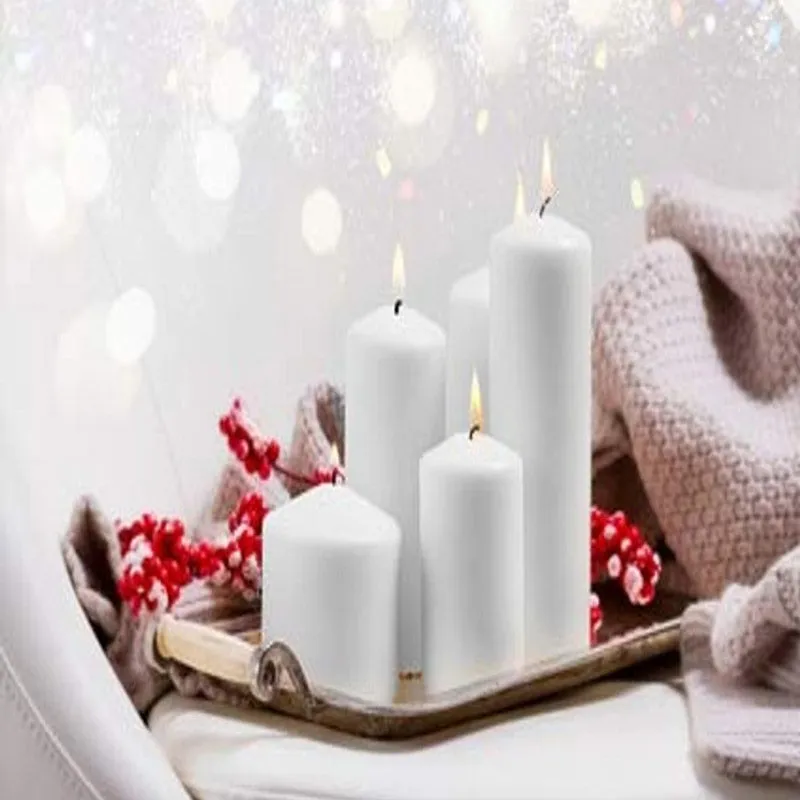 Four white pillar candles arranged on a tray with festive decor